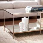 Tavolino rettangolare color oro con piano in vetro e ripiano inferiore