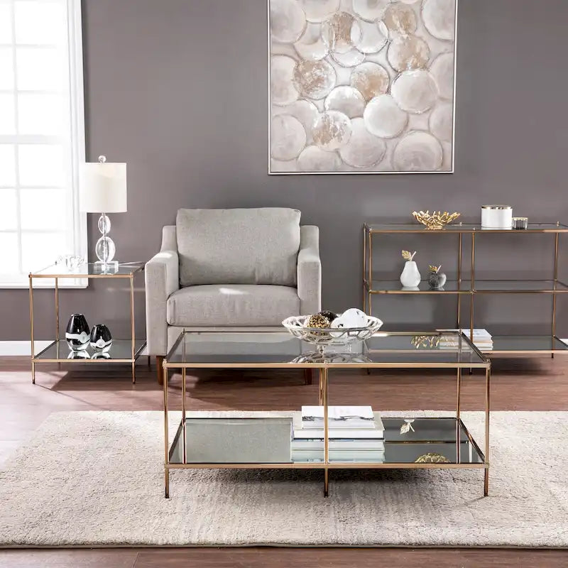 Tavolino rettangolare color oro con piano in vetro e ripiano inferiore
